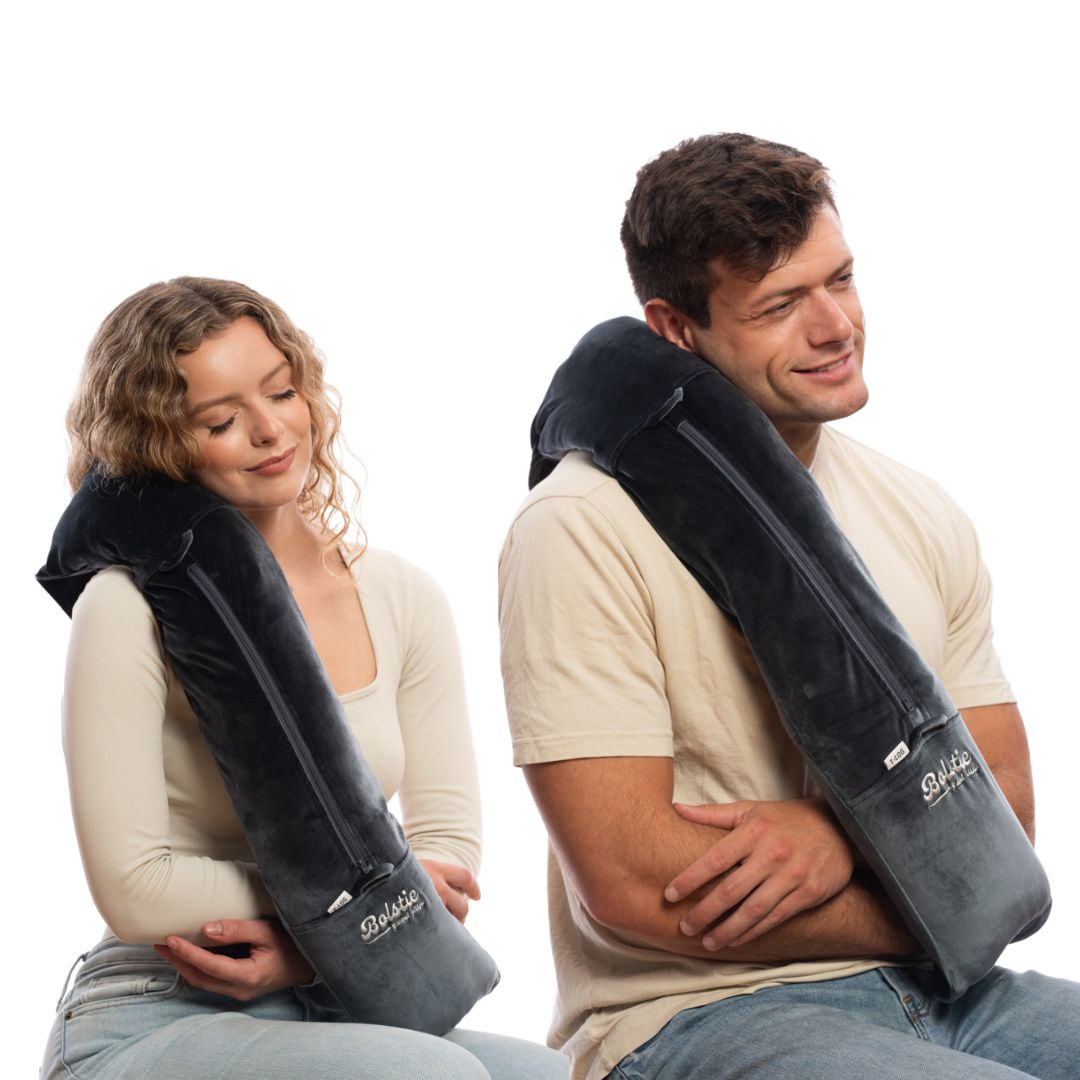 Couple using Bolstie travel pillow for long haul flight comfort without neck wrap